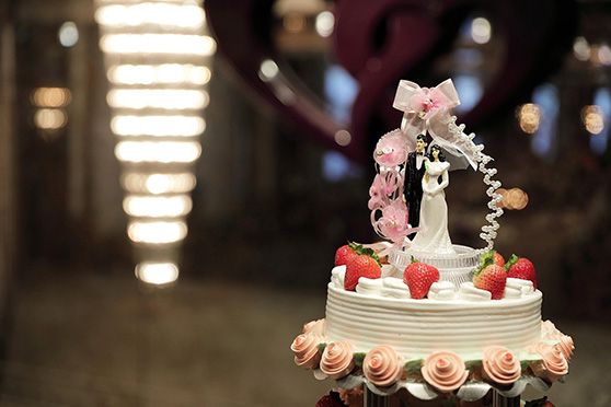 Three-tier white wedding cake with fresh strawberry garnish and a gold topper, symbolizing a future protected by a Colorado prenuptial agreement.