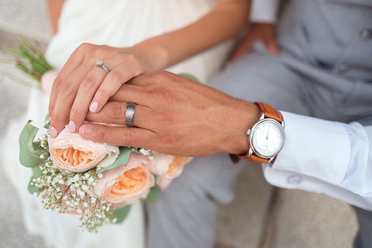 Couples hands with wedding rings for a Colorado marital agreement.